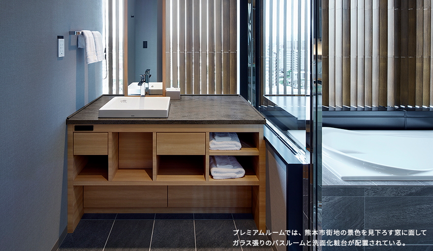 プレミアムルームでは、熊本市街地の景色を見下ろす窓に面してガラス張りのバスルームと洗面化粧台が配置されている。